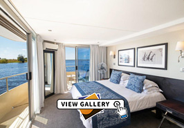Luxury Suite with bed, balcony and view of river