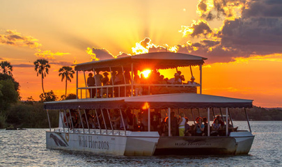 Boat on the Zambezi river at sunset with orange glow around